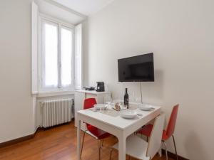 a white dining room with a white table and red chairs at The Best Rent - Spacious Two-bedroom apartment in Porta Romana in Milan