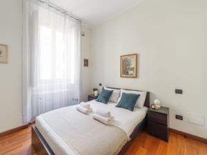 a bedroom with a large white bed with blue pillows at The Best Rent - Spacious Two-bedroom apartment in Porta Romana in Milan
