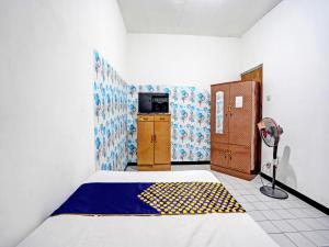 1 dormitorio con 1 cama con manta amarilla y azul en SPOT ON 92652 Meir E-homestay 2 Syariah, en Surabaya