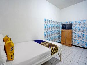 1 dormitorio con 1 cama y TV. en SPOT ON 92652 Meir E-homestay 2 Syariah, en Surabaya