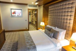 ein Schlafzimmer mit einem großen Bett und einer gepolsterten Wand in der Unterkunft Qalaalti Hotel & Spa in Galaalti
