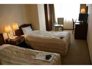 Cette chambre comprend deux lits et une télévision. dans l'établissement Ichihara Marine Hotel - Vacation STAY 01372v, à Ichihara
