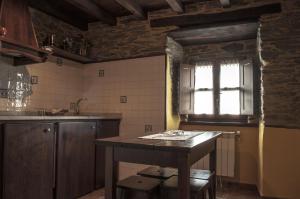 a kitchen with a table and a window at Apartamentos A Retoral in Coaña