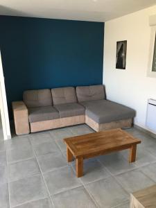a living room with a couch and a coffee table at Maison située entre plage la mine d'or et bourg in Pénestin