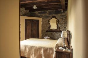 a bedroom with a bed and a mirror on the wall at Apartamentos A Retoral in Coaña