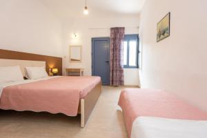 a hotel room with two beds and a window at Hotel Coral Matala in Matala