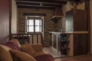 a living room with a couch and a kitchen at Apartamentos A Retoral in Coaña