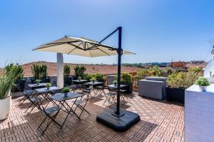 a patio with tables and an umbrella on a roof at Effe Luxury Palace in Rome