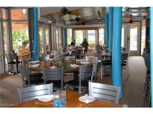a restaurant with tables and chairs and people in the background at Park Shore Resort Modern Waterview 2 Bed 2 Baths in Naples