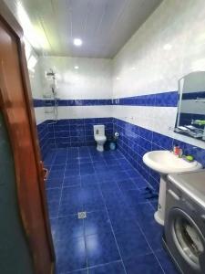 Baño de azulejos azules con aseo y lavamanos en Fairy house, en Gabala