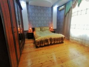 Schlafzimmer mit einem Bett und Holzboden in der Unterkunft Fairy house in Qəbələ