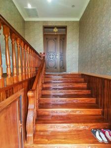 eine Holztreppe mit einer Tür in einem Zimmer in der Unterkunft Fairy house in Qəbələ