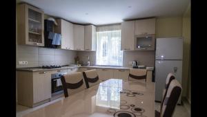 a kitchen with a glass table and a refrigerator at LOVELY HOUSE BAKURIANI in Bakuriani