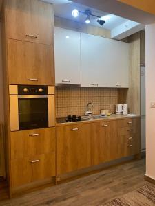 a kitchen with wooden cabinets and a sink at Mountain house Ivanova Korita in Cetinje