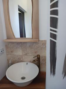 La salle de bains est pourvue d'un lavabo blanc et d'un miroir. dans l'établissement Cabana Trei Brazi Colibita, à Colibiţa
