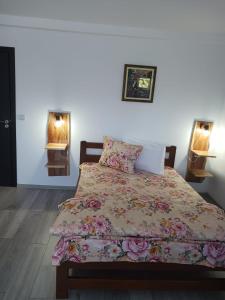 - une chambre dotée d'un lit avec un couvre-lit floral dans l'établissement Cabana Trei Brazi Colibita, à Colibiţa