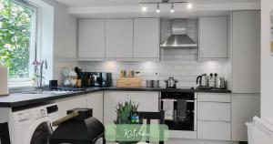 una cucina con mobili bianchi e un forno a piano cottura di Central Apart Hotel 2BR & 1BR Flats-EASY Walk to City Centre-Parking a Cambridge