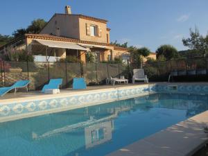 a villa with a swimming pool in front of a house at Appartement les Balcons d'Azur in Vernègues