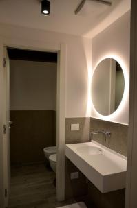 a bathroom with a sink and a mirror and a toilet at Casa Narciso in Lazise