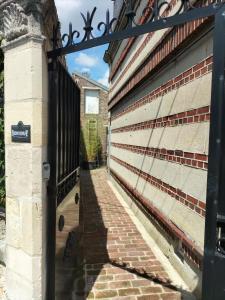 einen Eingang zu einem Gebäude mit einem schwarzen Tor in der Unterkunft Studio - Au fond de la cour in Lacroix-Saint-Ouen