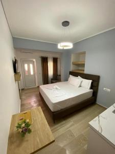 a bedroom with a large bed and a table at RIAN GUEST HOUSE in Sarandë