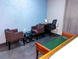 uma sala de espera com uma mesa de pingue-pongue e cadeiras em Golden Touch Executive Hotel em Tema