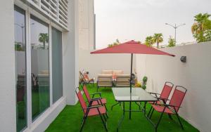 a patio with a table and chairs and an umbrella at Exquisite Villa - Elegant Living in Dubai