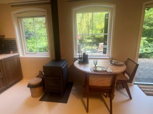 a dining room with a table and two windows at B&B Lekkerkerk in Lekkerkerk