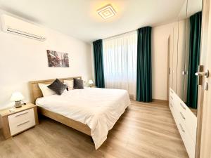 a bedroom with a large bed and a window at Urban Plaza Astra - Rise Private Apartments & Suites in Braşov