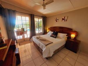 a bedroom with a bed and a large window at Highlands Creek Self Catering Accommodation in Nelspruit