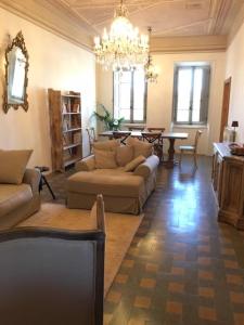 sala de estar con sofás, mesa y lámpara de araña en Rooftop apartment in Medieval Italian City, en Foligno