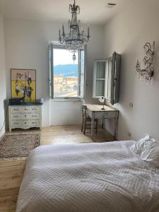 1 dormitorio con cama, escritorio y ventana en Rooftop apartment in Medieval Italian City, en Foligno