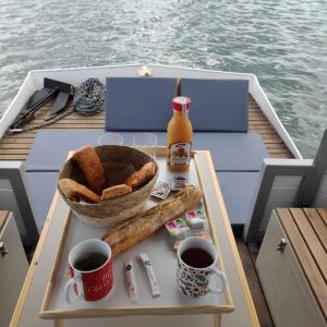 a table with bread and drinks on a boat at Bateau logement nuit Insolite Astragale in Lège-Cap-Ferret