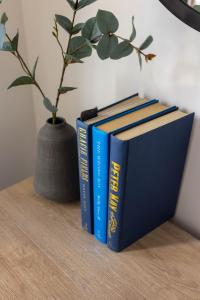 three books sitting on a table next to a vase at Host Liverpool - Spacious Home for Family & Groups in Liverpool