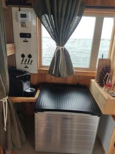 a kitchen with a window on a boat at Bateau logement nuit Insolite Astragale in Lège-Cap-Ferret +8 photos