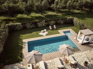 una vista sul soffitto di una piscina con sedie e ombrelloni di La Maison Du Maire Luxury Villa a Sarakinádhon