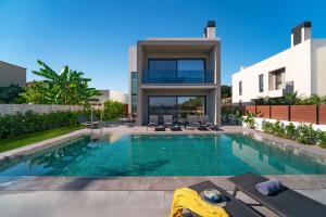 a swimming pool in front of a house at Momentum Villas in Ialyssos