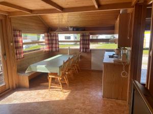 een keuken met een tafel en stoelen in een kamer bij Midttun Camping og Feriehytter in Vossestrand