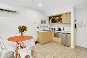 a kitchen and dining room with a table and chairs at Boathouse at Iluka Resort Apartments in Palm Beach