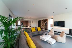 ein Wohnzimmer mit gelben Kissen und einer Couch in der Unterkunft Momentum Villas in Ialyssos