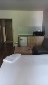 a bedroom with a white bed and a kitchen at Apartments KiM Sandanski in Sandanski