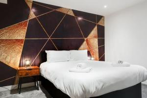 a bedroom with a large bed with a large wall at Victoria Stay - Parking Wi-Fi Amazing in Hyde