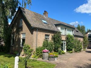 une maison en briques avec des fleurs dans une allée dans l'établissement B&B Lekkerkerk, à Lekkerkerk