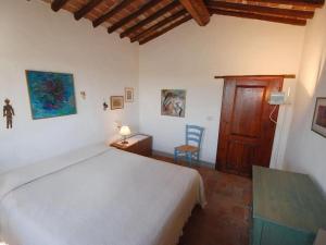 een slaapkamer met een wit bed en een houten deur bij Country House in Chianti Da Vieri in Certaldo