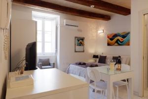 eine Küche und ein Wohnzimmer mit einem Tisch und einem Bett in der Unterkunft SPQR Studios 2 Valletta in Valletta