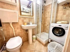 uma casa de banho com um lavatório e uma máquina de lavar roupa em Un petit coin proche de la mer em Menton