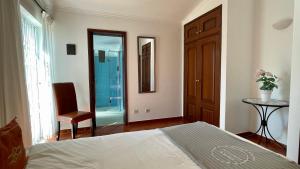 um quarto com uma cama, uma cadeira e uma janela em Poço by Check-in Portugal em Albufeira
