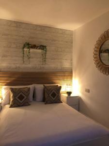 een slaapkamer met een groot wit bed en een spiegel bij Ocean Drive Boutique Apartment complimentary Tray in Brean