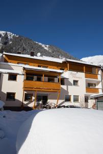 a large building with snow in front of it at Apart Altamira in Ischgl