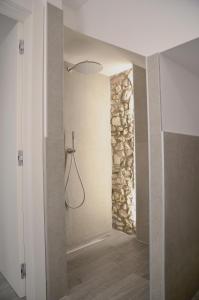 a bathroom with a shower with a stone wall at Casa Narciso in Lazise